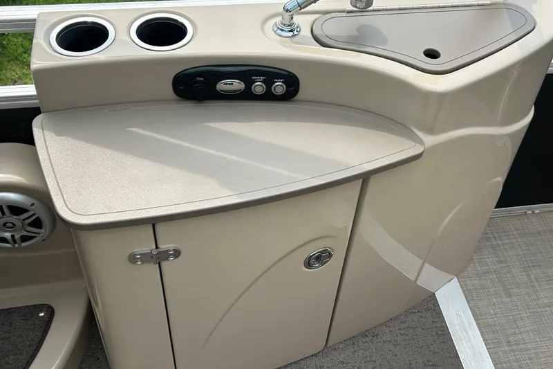 Slide: The Image of 2014 Regency 220 DL3 boat console with sink, cup holders, and storage cabinet. - 17