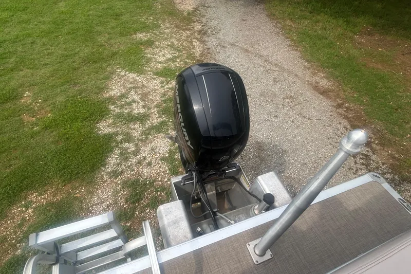 Slide: The Image of 2014 Regency 220 DL3 boat with Mercury outboard motor on gravel path. - 18