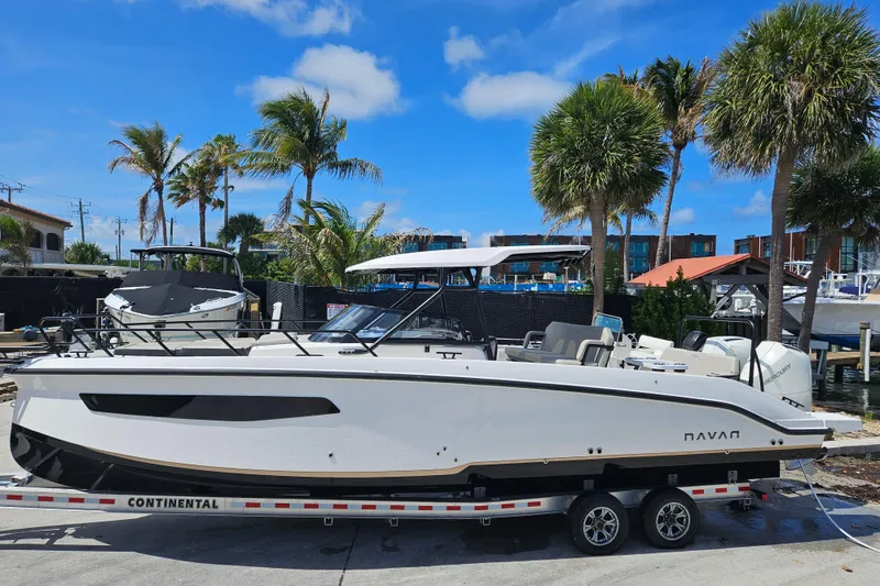 The Image of Navan S30 boat 2026 on trailer, surrounded by palm trees. - 1