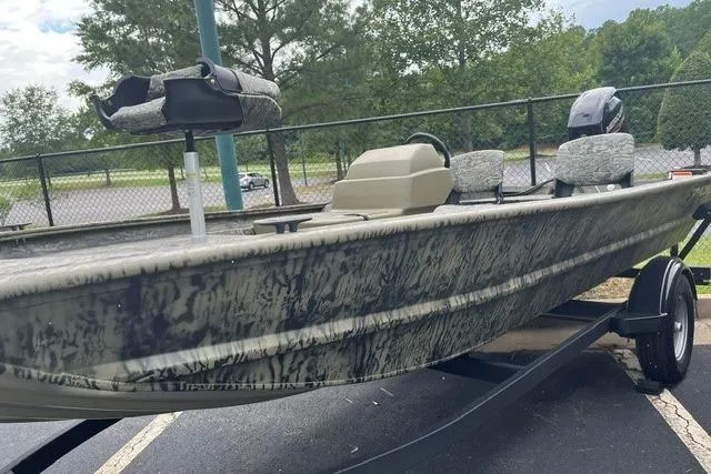 Slide: The Image of 2026 Tracker Grizzly 1754 SC boat on trailer, camo design, parked outdoors. - 3