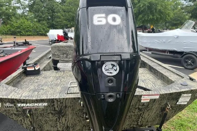 Slide: The Image of 2026 Tracker Grizzly 1754 SC boat with 60 HP engine in a parking lot. - 6
