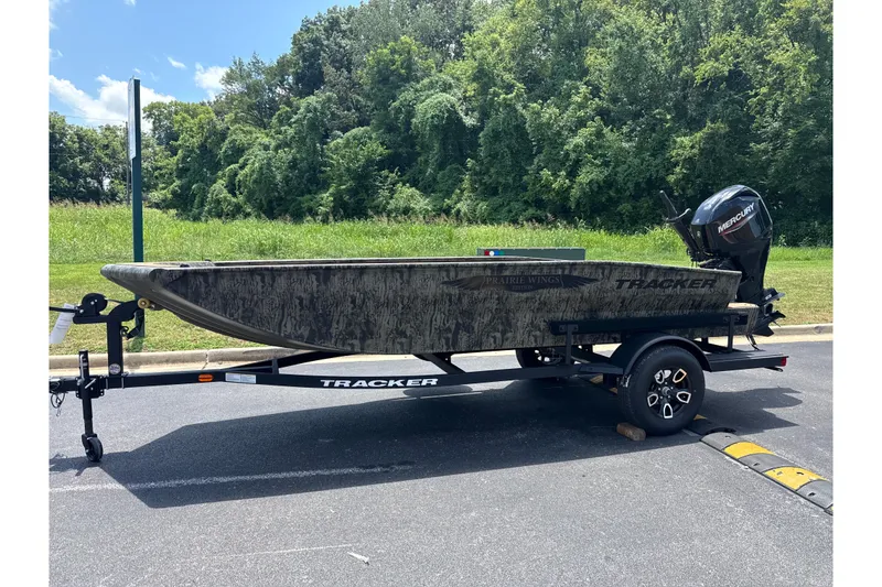 The Image of 2026 Tracker Grizzly 1650 T Prairie Wings Edition boat on trailer, parked outdoors. - 0