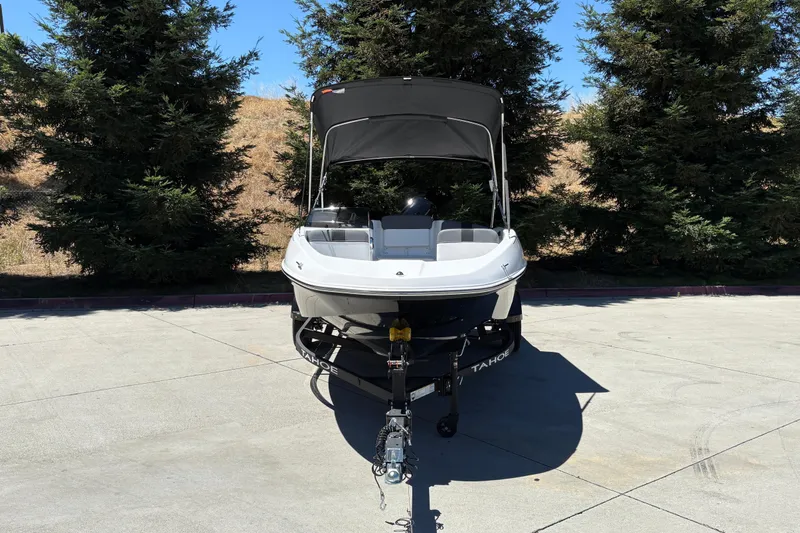 Slide: The Image of 2026 Tahoe T16 boat on trailer, parked outdoors with trees in the background. - 8
