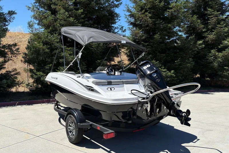 Slide: The Image of 2026 Tahoe T16 boat with canopy and outboard motor, parked on a trailer. - 5