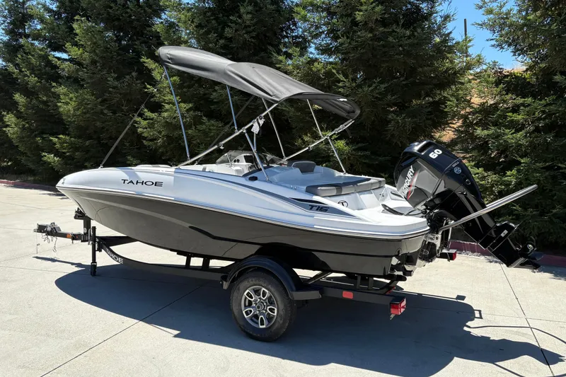 Slide: The Image of 2026 Tahoe T16 boat with canopy and Mercury 60 engine, parked outdoors. - 6