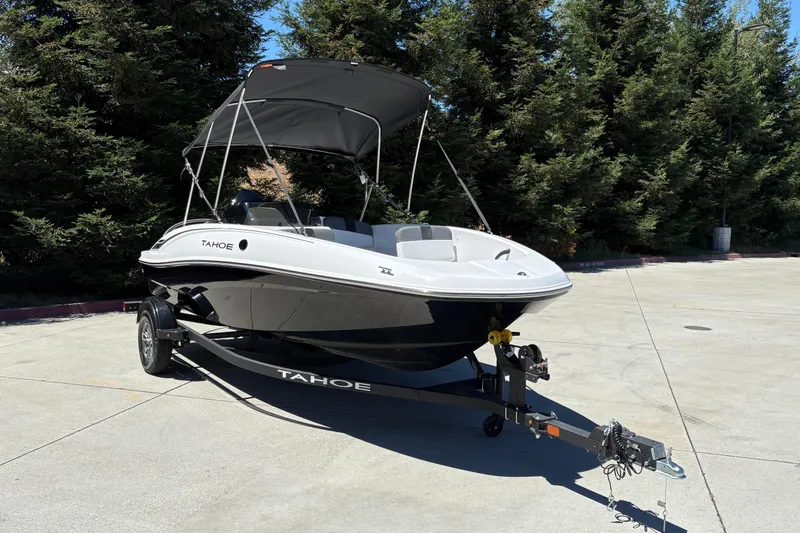 Slide: The Image of 2026 Tahoe T16 boat on trailer with canopy, parked outdoors. - 7