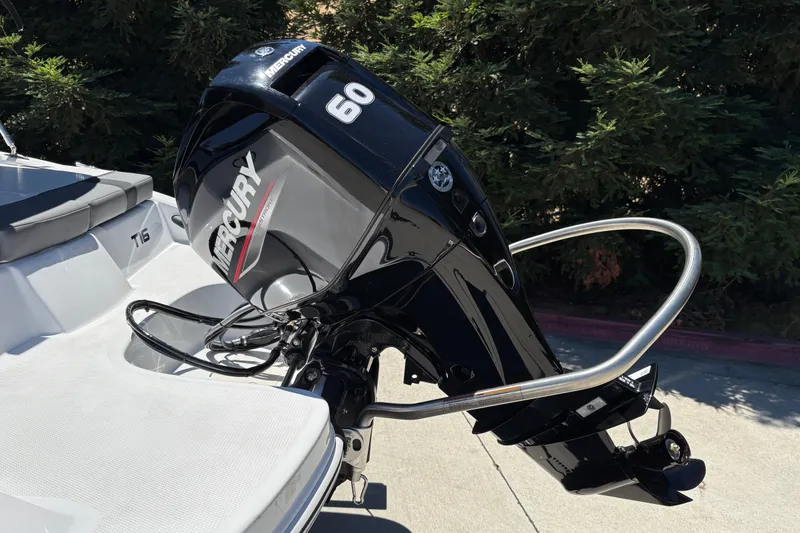 Slide: The Image of 2026 Tahoe T16 boat with Mercury 60 outboard motor, parked outdoors. - 26