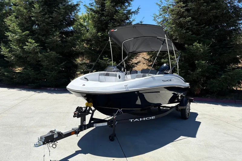 Slide: The Image of 2026 Tahoe T16 boat on trailer with canopy, parked outdoors. - 11