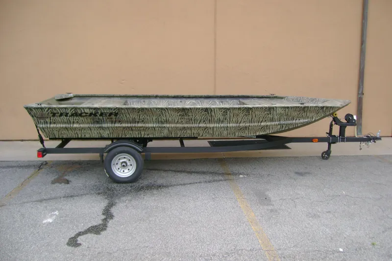 The Image of 2026 Tracker Grizzly 1648 Utility boat on trailer, featuring camouflage design. - 0