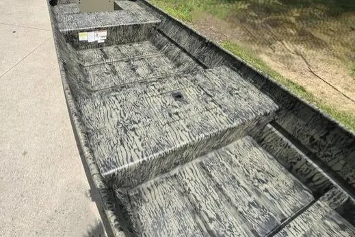 Slide: The Image of 2026 Tracker Grizzly 15 Jon boat with camouflage pattern, parked on concrete. - 3