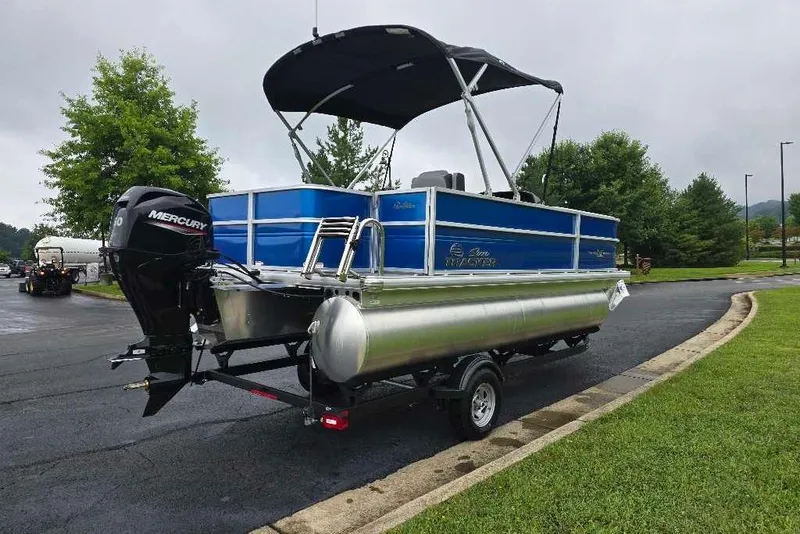 Slide: The Image of 2026 Sun Tracker Party Barge 18 DLX pontoon boat on trailer, parked on a paved road. - 5