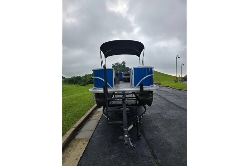 Slide: The Image of 2026 Sun Tracker Party Barge 18 DLX on trailer, parked on a paved road. - 4