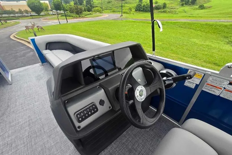 Slide: The Image of 2026 Sun Tracker Party Barge 18 DLX interior with steering wheel and seating. - 9