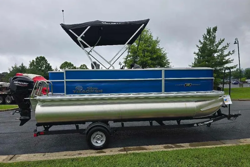 Slide: The Image of 2026 Sun Tracker Party Barge 18 DLX pontoon boat on trailer, parked outdoors. - 2