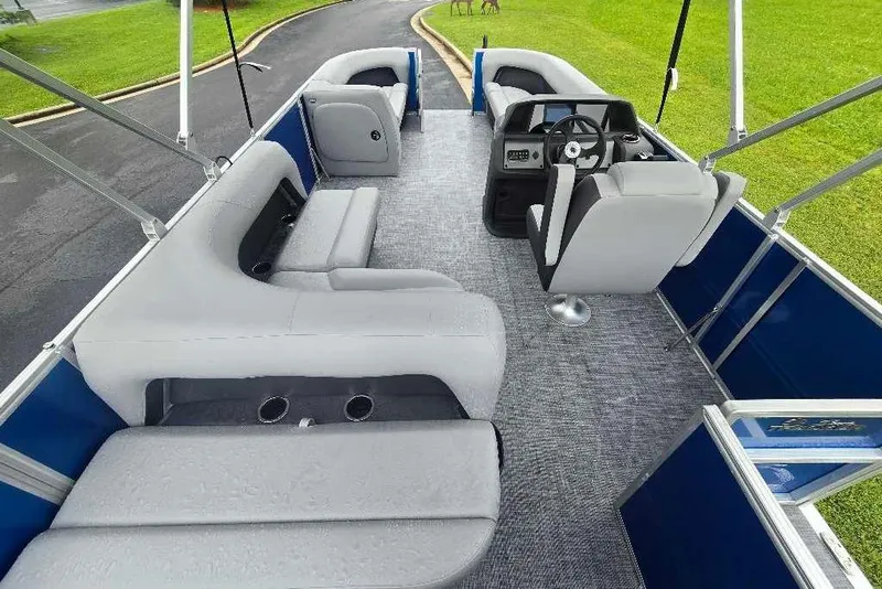 Slide: The Image of 2026 Sun Tracker Party Barge 18 DLX interior with gray seating and steering console. - 8