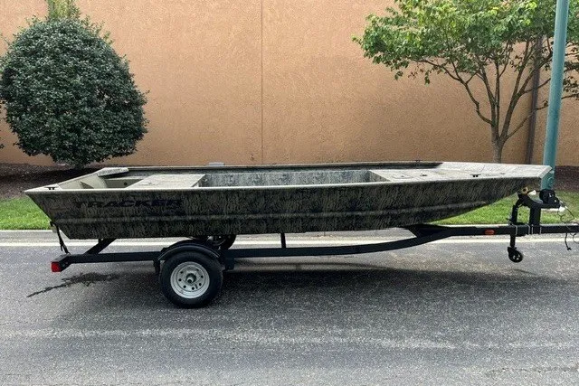 The Image of 2026 Tracker Grizzly 1648 Utility boat on trailer, parked outdoors. - 0