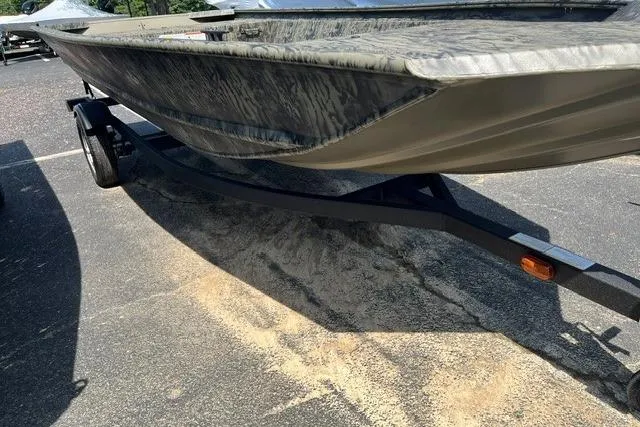 The Image of 2026 Tracker Grizzly 1648 Utility boat on trailer, parked on asphalt. - 0