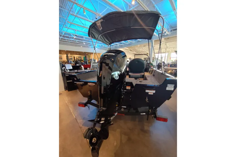 Slide: The Image of 2026 Tracker Pro Guide V-16 WT boat displayed indoors with canopy and motor. - 6