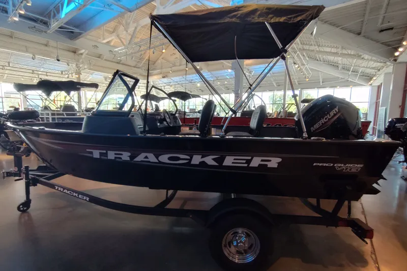 Slide: The Image of 2026 Tracker Pro Guide V-16 WT boat displayed in a showroom with canopy and Mercury engine. - 5