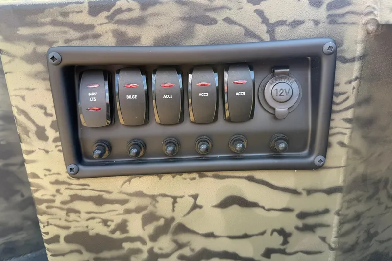 Slide: The Image of Control panel of 2026 Tracker Grizzly 1650 T Prairie Wings Edition with switches and 12V outlet. - 8