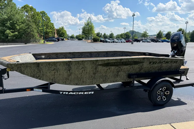 Slide: The Image of 2026 Tracker Grizzly 1650 T Prairie Wings Edition boat on trailer in parking lot. - 3