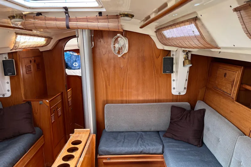 Slide: The Image of 1986 Wauquiez Petorine yacht interior with wooden paneling and cozy seating area. - 10