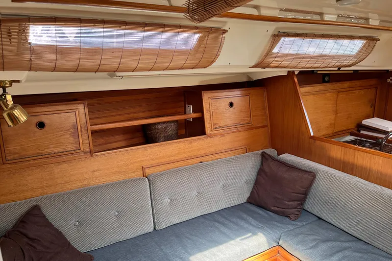 Slide: The Image of Interior of a 1986 Wauquiez Petorine yacht with wooden cabinetry and cushioned seating. - 11