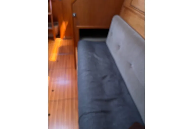 Slide: The Image of Interior of 1986 Wauquiez Petorine sailboat with wooden flooring and cushioned seating. - 13