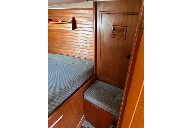 Slide: The Image of 1986 Wauquiez Petorine cabin interior with wooden paneling and cushioned seating. - 15