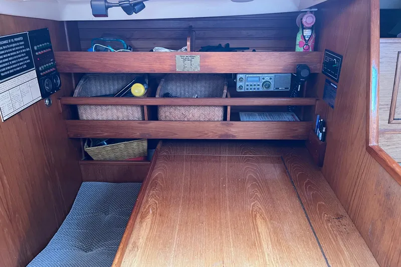 Slide: The Image of 1986 Wauquiez Petorine cabin interior with wooden shelves and nautical equipment. - 16