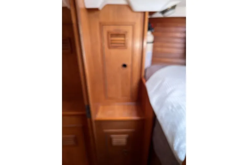 Slide: The Image of Interior of 1986 Wauquiez Petorine yacht, featuring wooden cabinetry and cozy sleeping area. - 19