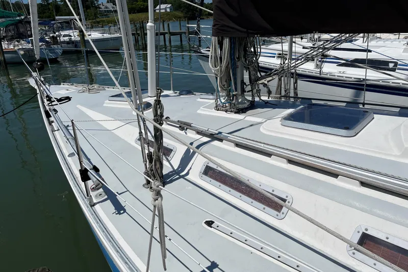 Slide: The Image of 1986 Wauquiez Petorine sailboat deck with rigging, docked in a marina. - 2