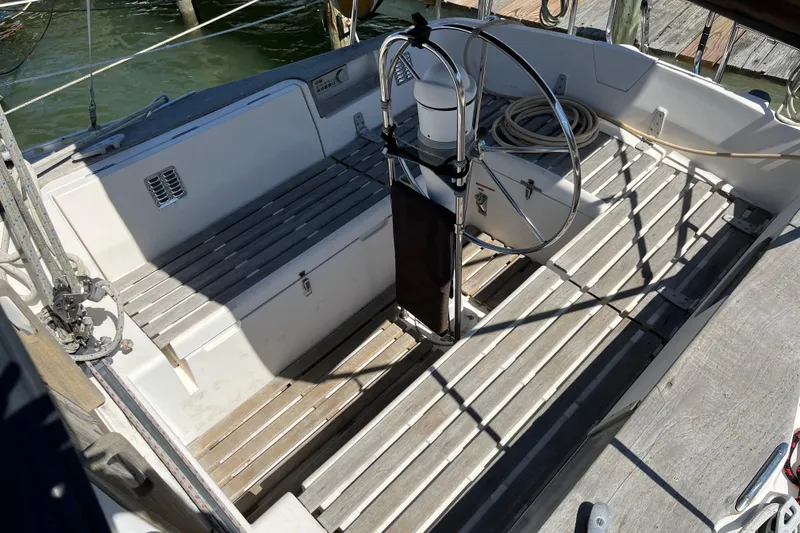 Slide: The Image of 1986 Wauquiez Petorine sailboat cockpit with wooden flooring and steering wheel. - 3