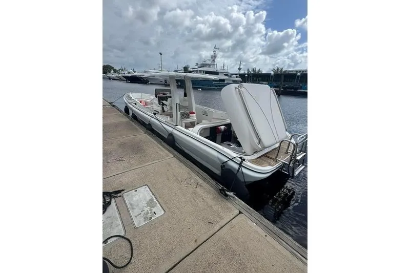 Slide: The Image of 2012 Novurania Chase boat docked at marina under cloudy sky. - 2