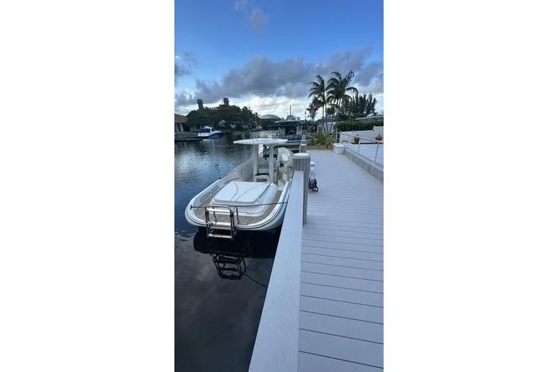Slide: The Image of 2012 Novurania Chase boat docked by a waterfront with palm trees and cloudy sky. - 4