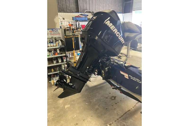 Slide: The Image of 2012 Bass Tracker Pro 17 with Mercury outboard motor in a workshop setting. - 17