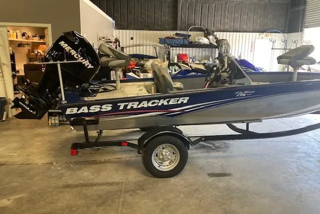 Slide: The Image of 2012 Bass Tracker Pro 17 boat with Mercury engine in a garage setting. - 4