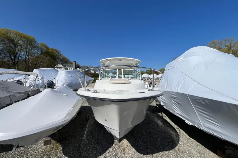 Slide: The Image of 2009 Hydra-Sports 2000 WA boat in storage, surrounded by covered vessels under clear blue sky. - 23