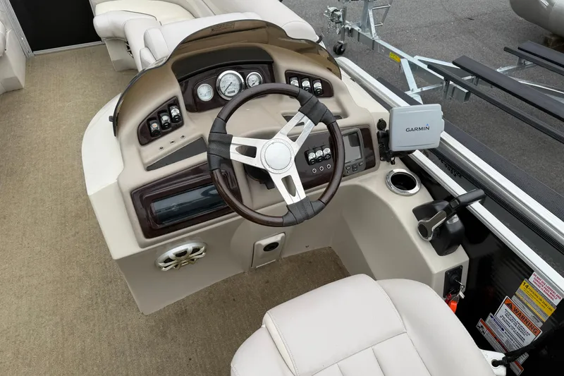Slide: The Image of 2013 Bennington 2375 GCW boat dashboard with steering wheel and Garmin navigation system. - 14