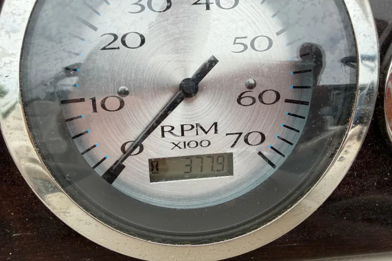 Slide: The Image of Close-up of a 2013 Bennington 2375 GCW RPM gauge displaying 377.9 hours. - 6