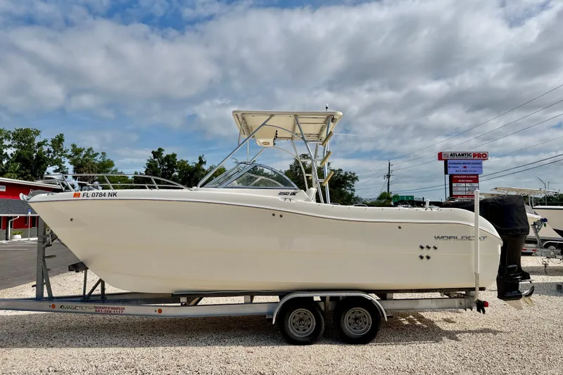 The Image of 2007 World Cat 250 DC boat on trailer, parked outdoors under cloudy sky. - 0
