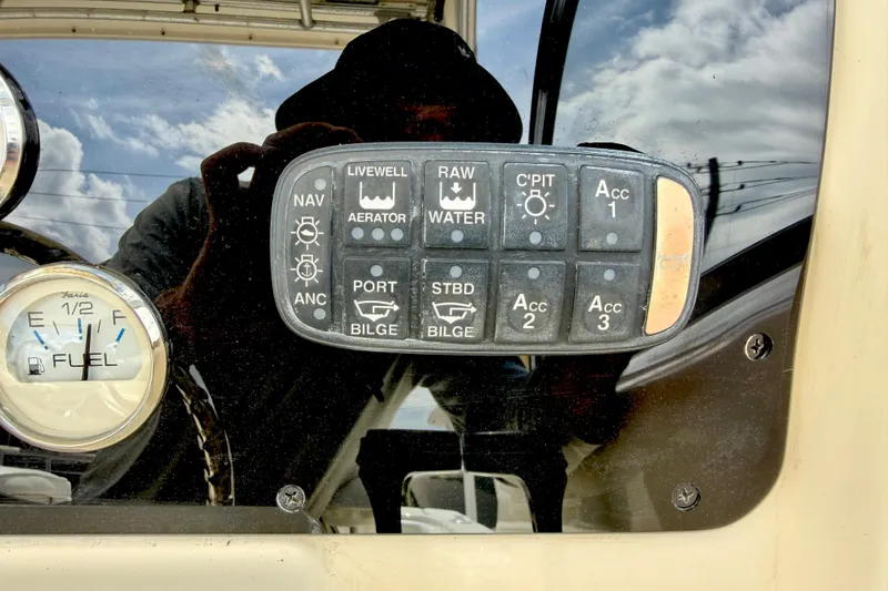 Slide: The Image of Control panel of a 2007 World Cat 250 DC boat with various switches and fuel gauge. - 13