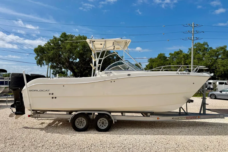 Slide: The Image of 2007 World Cat 250 DC boat on trailer, parked outdoors under blue sky. - 4