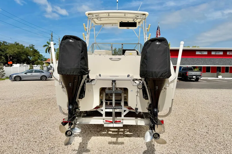 Slide: The Image of 2007 World Cat 250 DC boat with dual outboard motors, parked on gravel. - 6