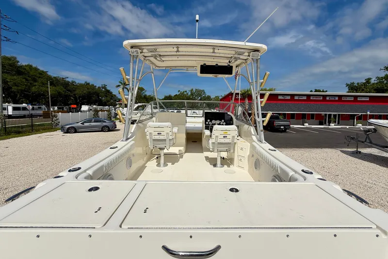 Slide: The Image of 2007 World Cat 250 DC boat with spacious deck and seating, parked outdoors. - 8