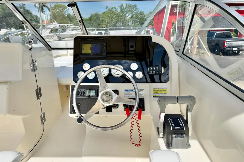 Slide: The Image of 2007 World Cat 250 DC boat cockpit with steering wheel and control panel. - 9