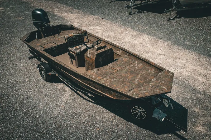 The Image of 2026 G3 Gator Tough 18 CCJ boat on trailer, camo design, parked outdoors. - 1