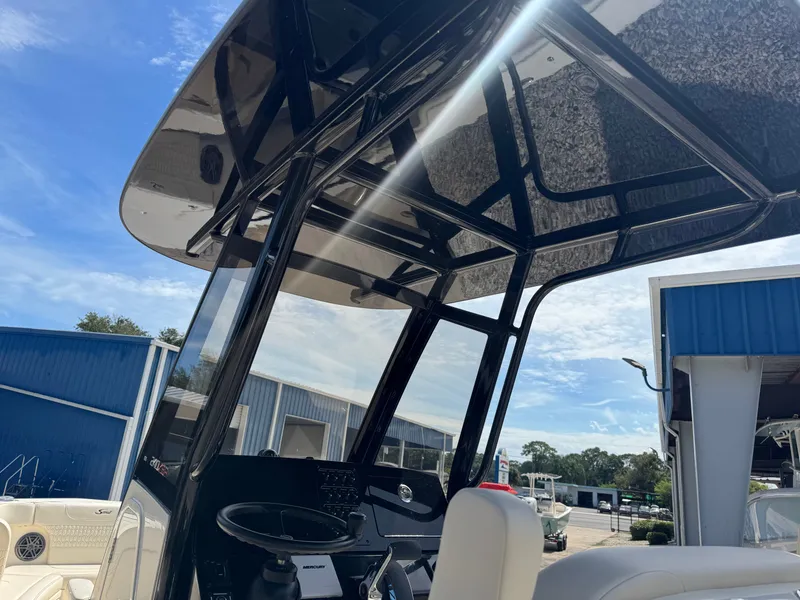 Slide: The Image of The image shows the cockpit of a Scout 240 XSF boat with a black T-top. - 17