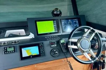 Slide: The Image of 2018 Axopar 37 XC CROSS CABIN dashboard with navigation screens and steering wheel. - 18
