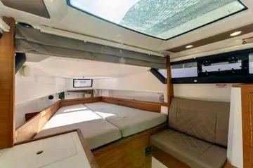 Slide: The Image of 2018 Axopar 37 XC CROSS CABIN interior with skylight, bed, and seating area. - 25